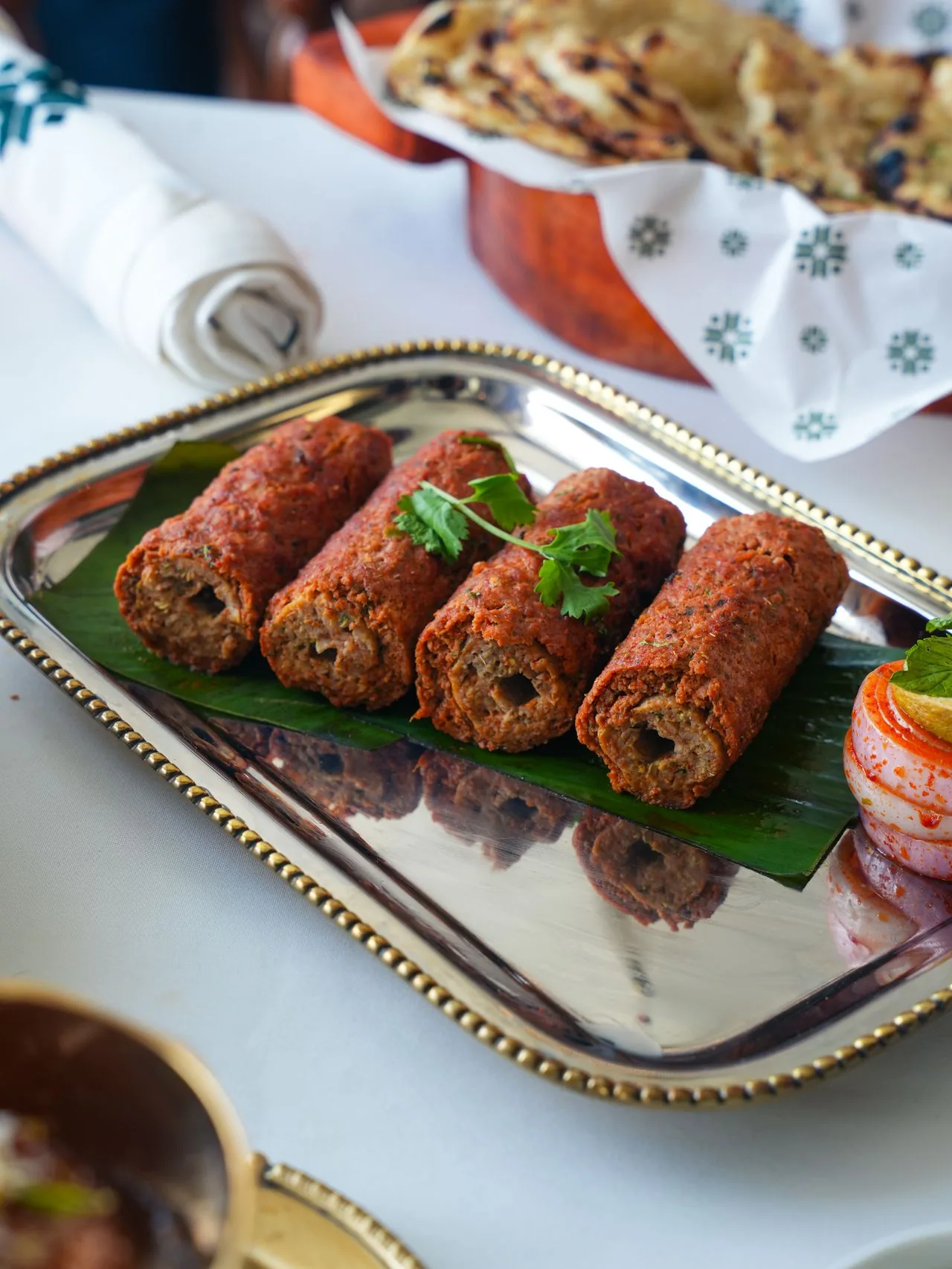 Seekh kebabs on a silver platter with naan (illustrative photo)