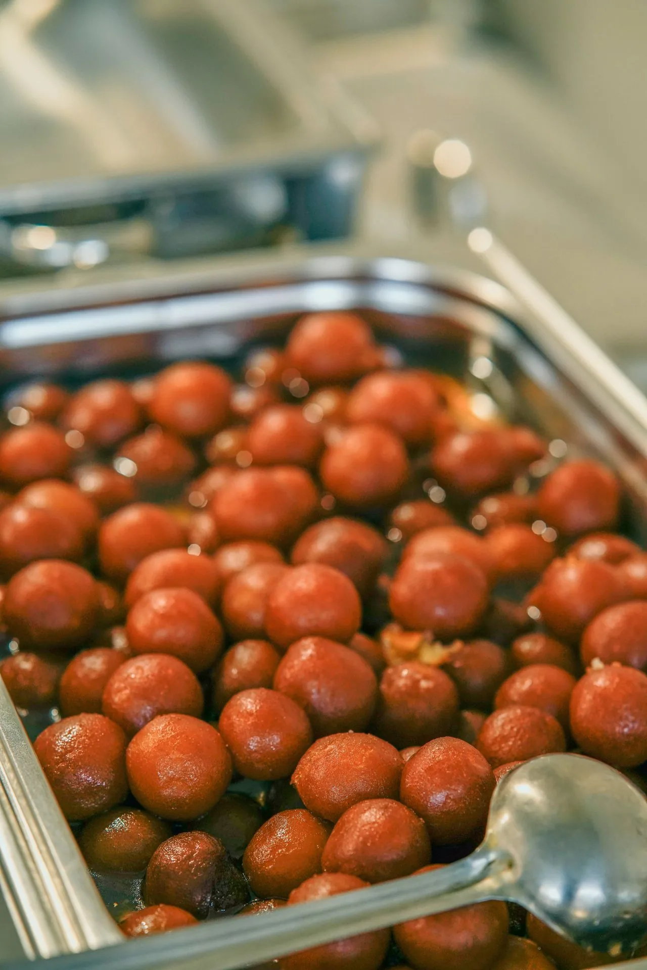 Tray of gulab jamun for a Walima celebration dessert counter (illustrative photo)